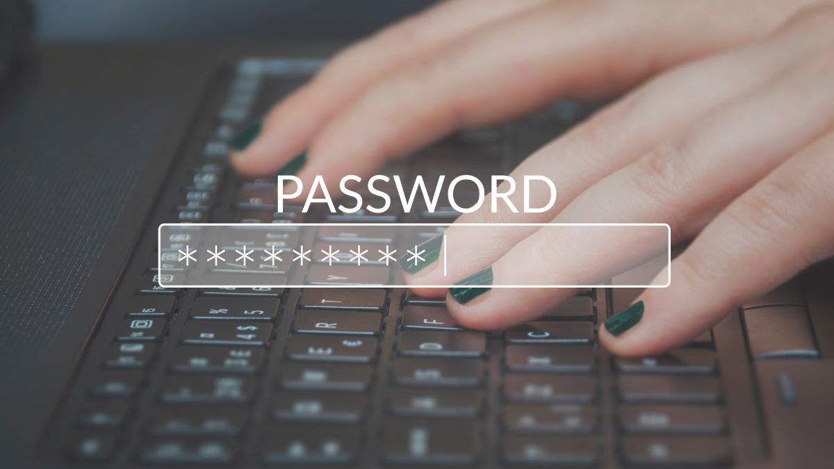 Egy kéz gépel egy jelszót a laptop billentyűzetén, zöld körömmel.