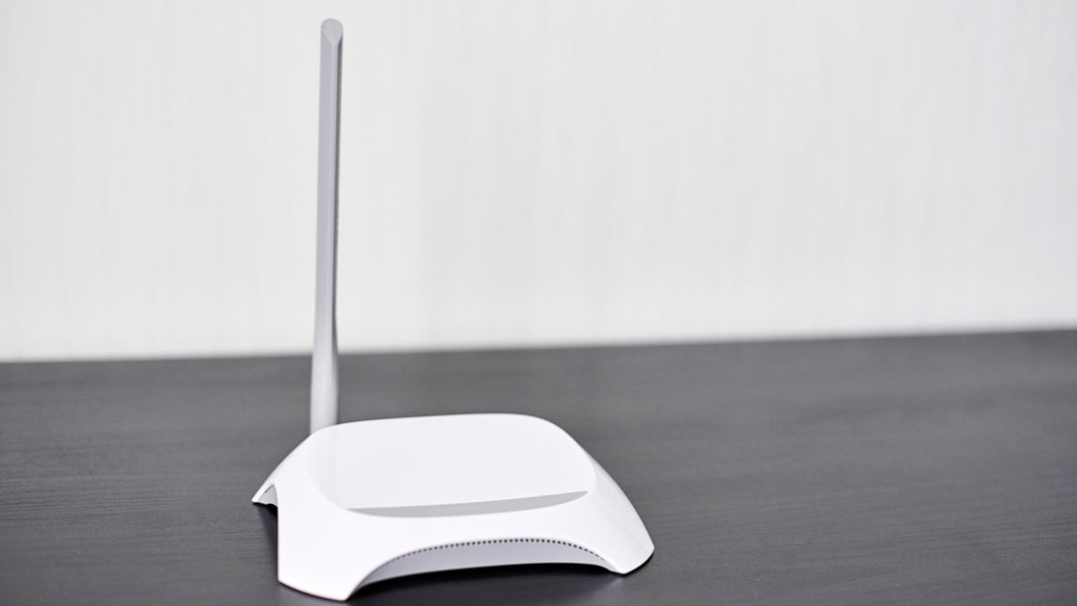 Egy fehér színű router, amely az otthoni hálózatok IP-cím kiosztásáért felelős.