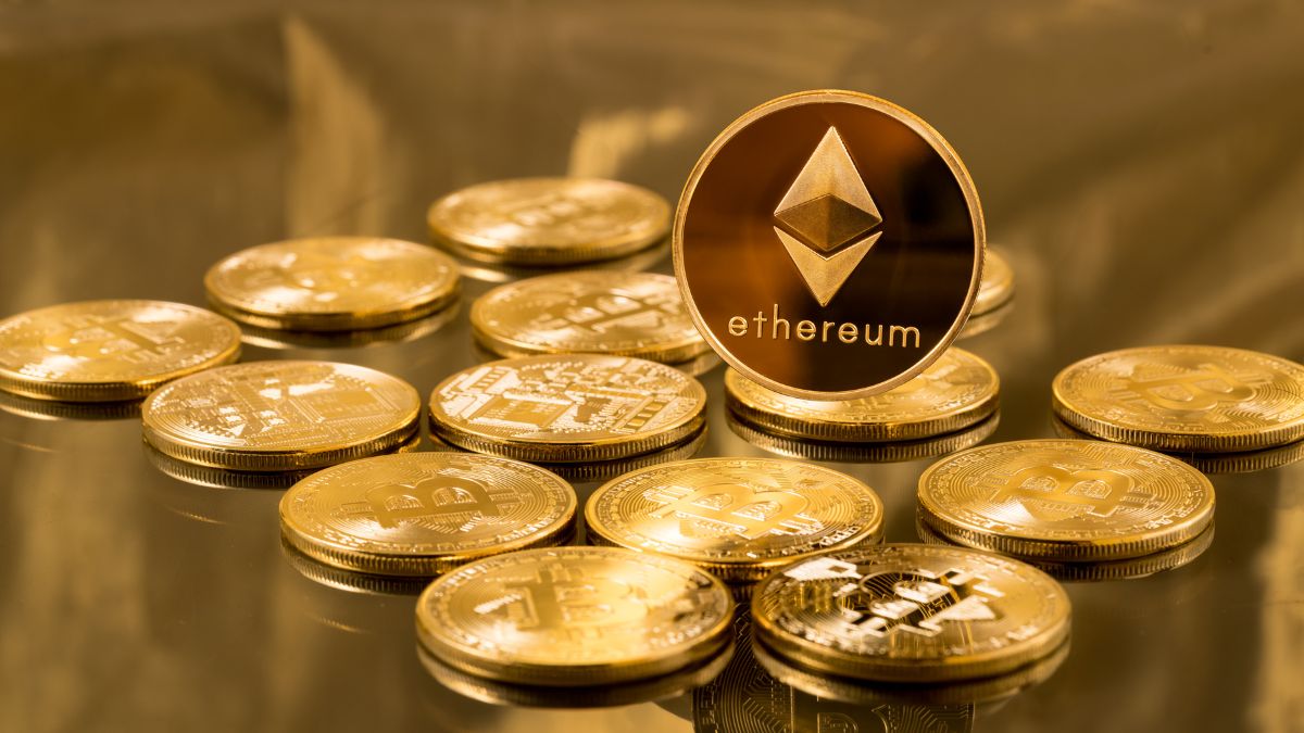 Egy Ethereum érme kiemelkedik más kriptovaluták közül, arany háttér előtt.