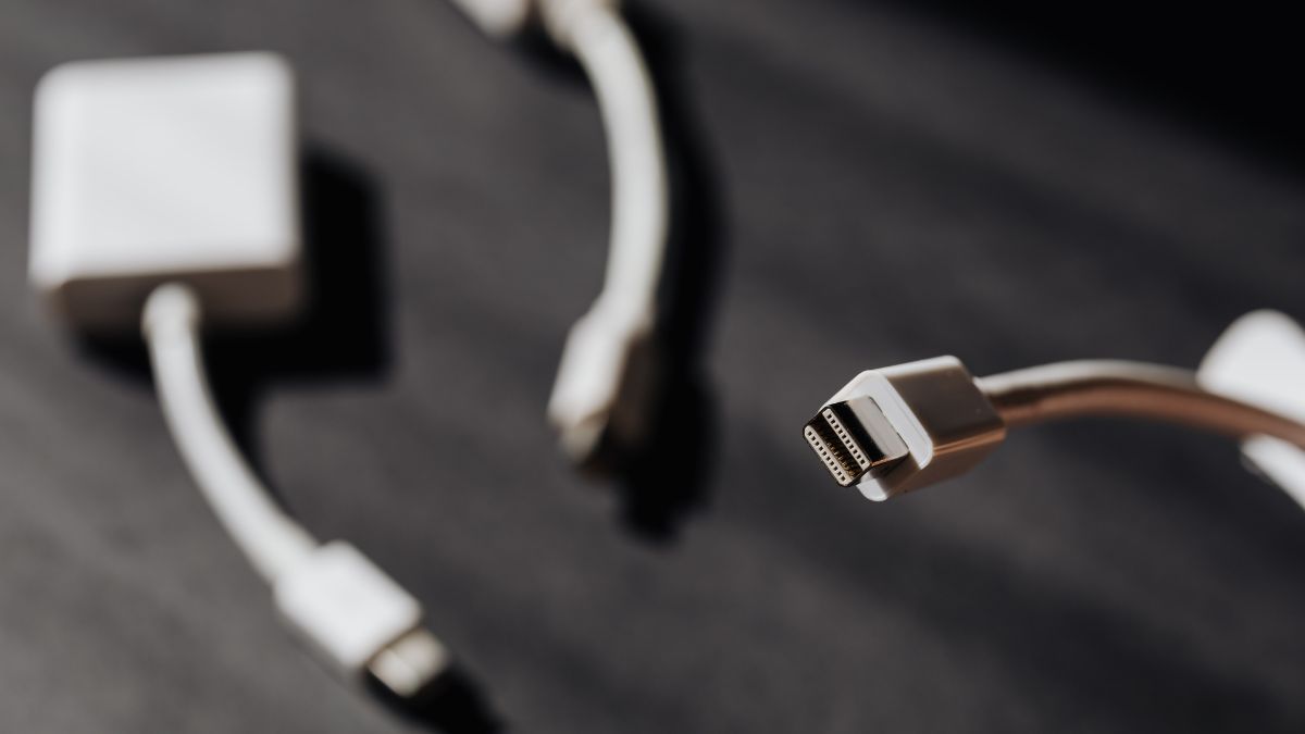Különböző kábelek és átalakítók láthatók, amelyek a modern technológiához szükségesek.