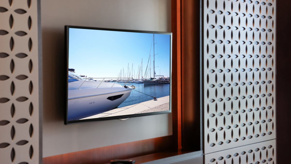 Egy plazma TV, amelyen hajók láthatók egy kikötőben, világos időben.