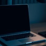 Egy ki nem kapcsolt laptop a sötétben, mellette egy egér