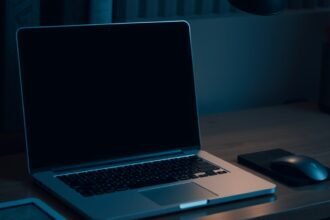 Egy ki nem kapcsolt laptop a sötétben, mellette egy egér