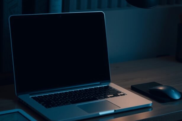 Egy ki nem kapcsolt laptop a sötétben, mellette egy egér